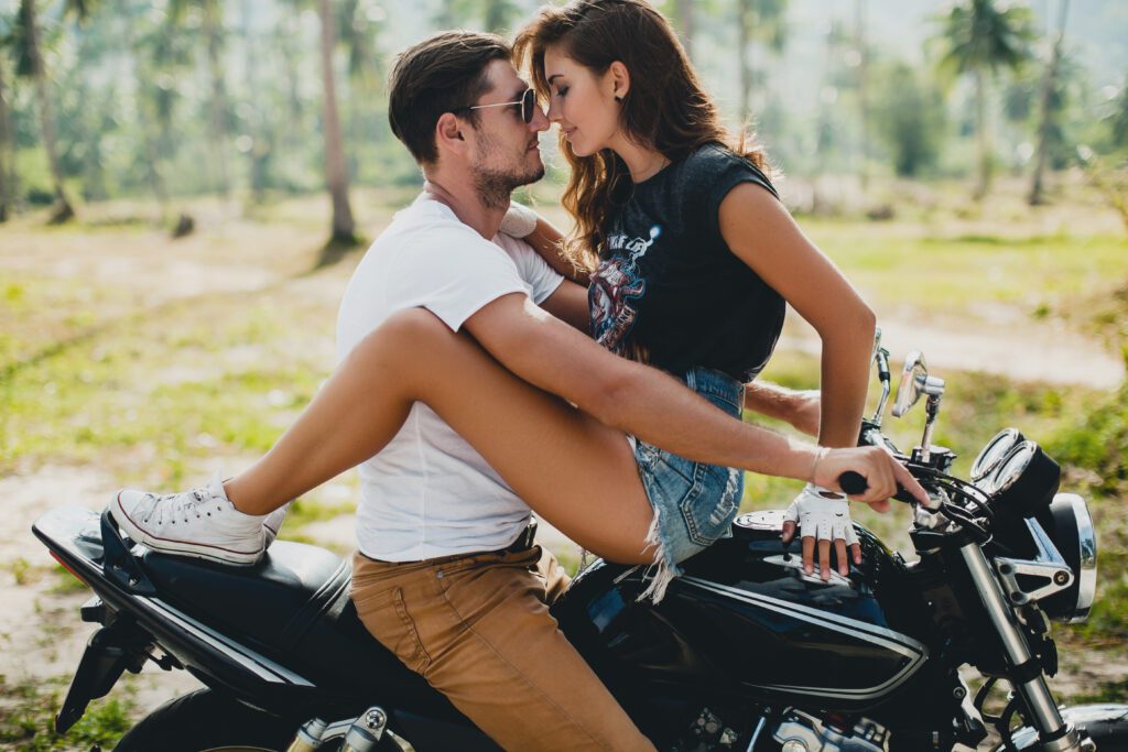 Couple sitting on top of a motorcycle